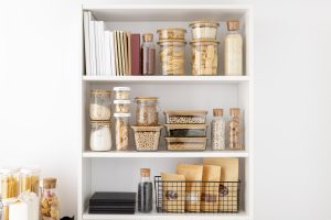 Modern kitchen with open shelving displaying stylish cookware and decor.