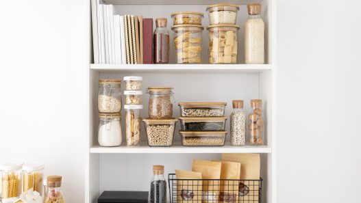 Modern kitchen with open shelving displaying stylish cookware and decor.