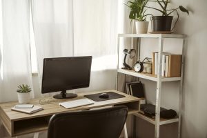 A stylish compact home office desk setup in a small, bright room.