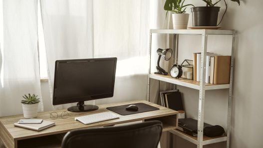 A stylish compact home office desk setup in a small, bright room.