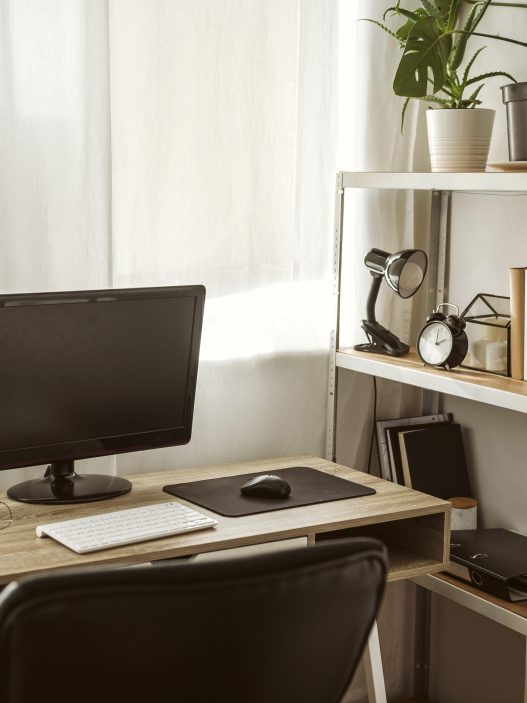 A stylish compact home office desk setup in a small, bright room.