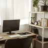 A stylish compact home office desk setup in a small, bright room.