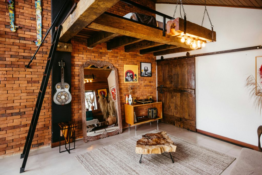 Wall-mounted wooden hooks holding linen bags and hats in an entryway with farmhouse vibes