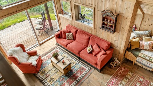 Farmhouse-style living room with rustic wall decor including wooden signs, shiplap, and greenery