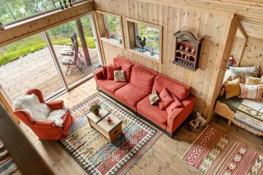 Farmhouse-style living room with rustic wall decor including wooden signs, shiplap, and greenery