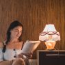 Cozy reading nook with warm lighting, armchair, and floor lamp by the window.